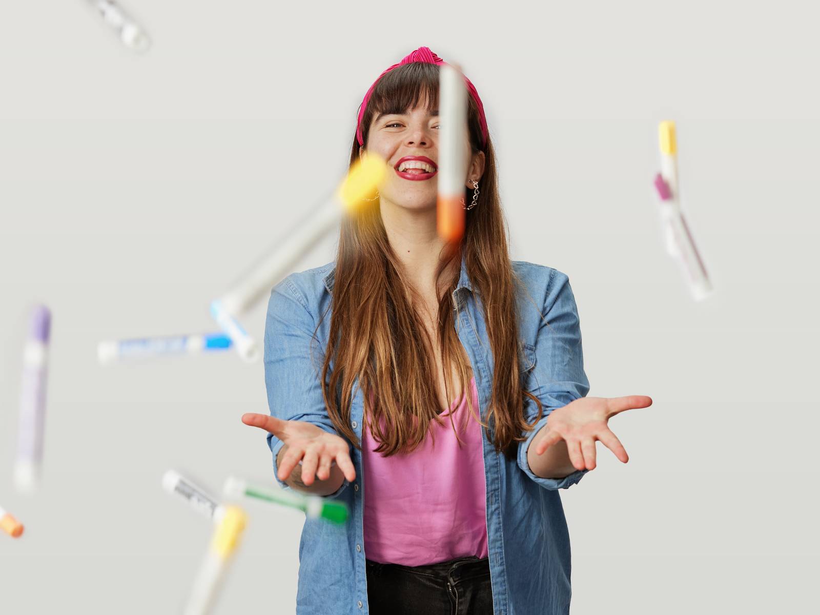 Camila throwing coloured pens.