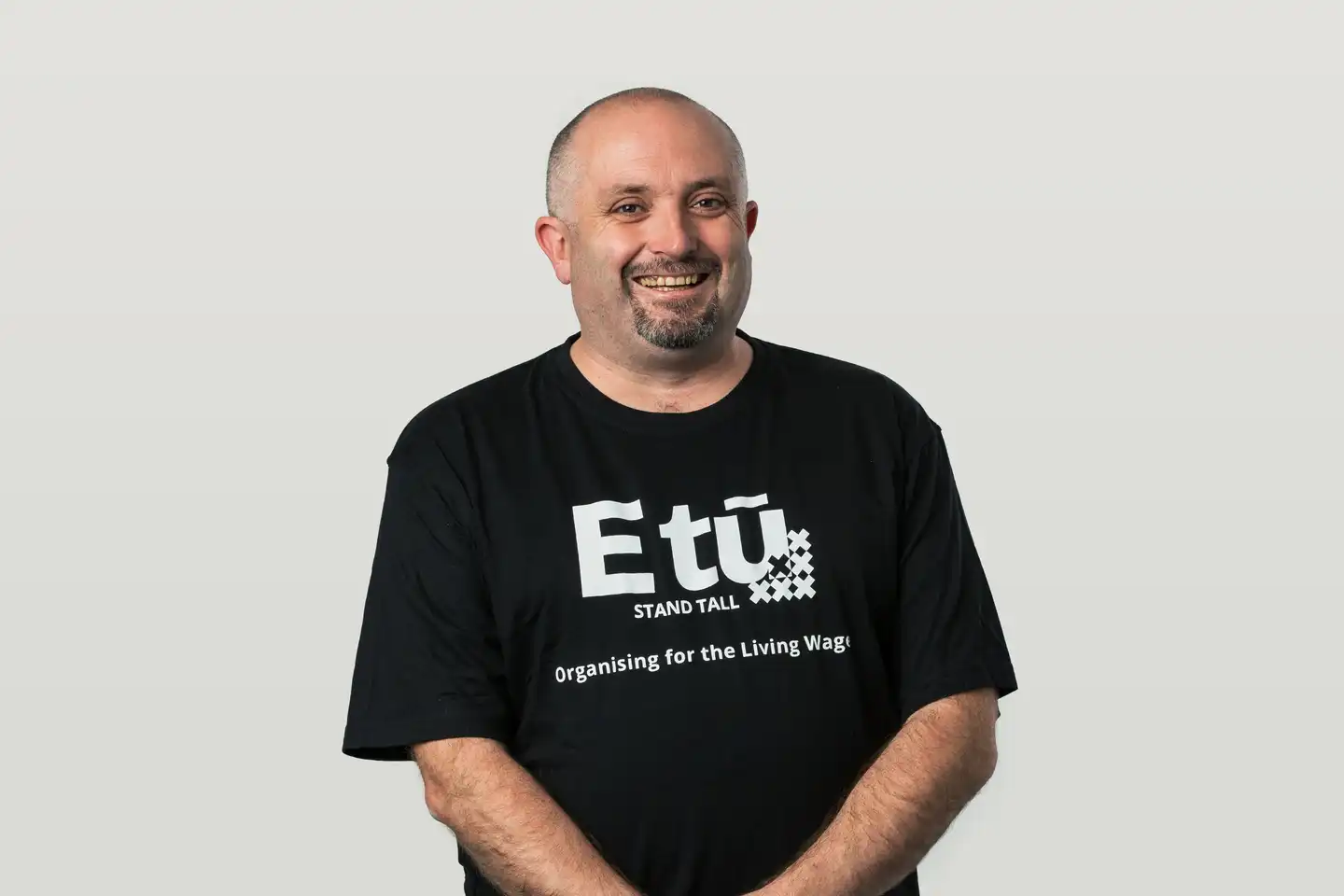 John in an 'E tū - Organising for the Living Wage' t-shirt