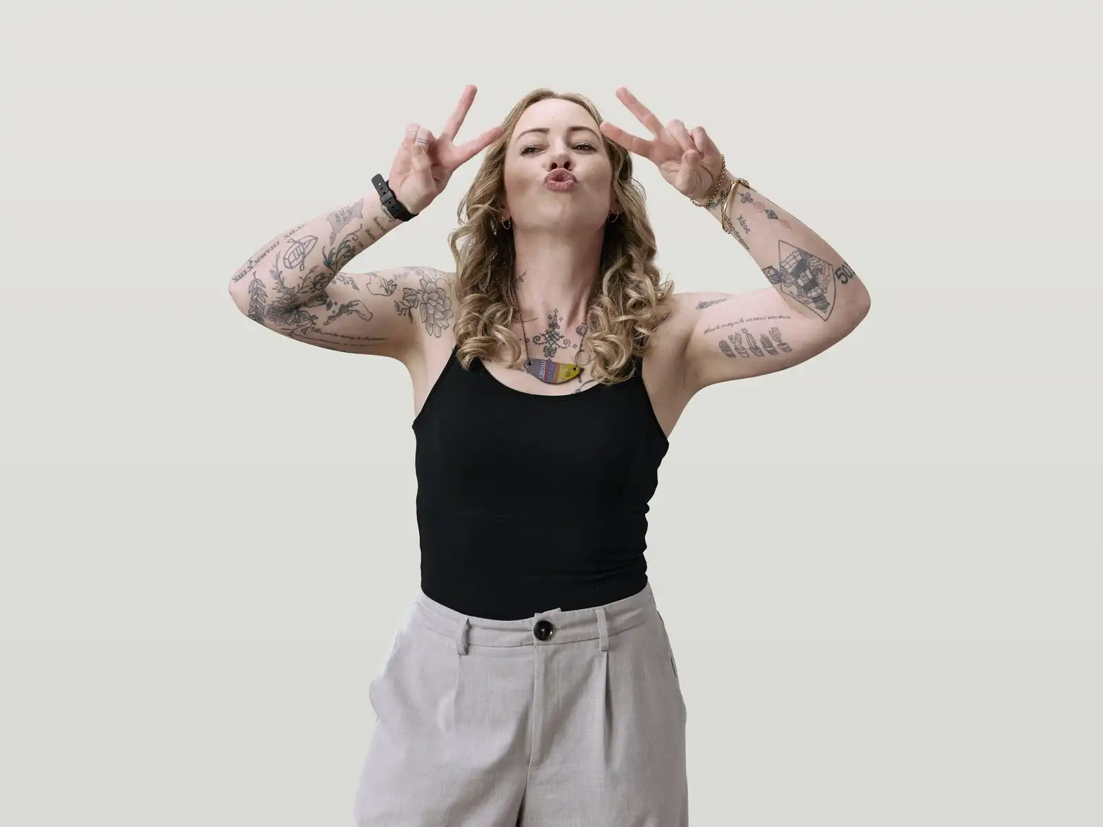 Keeley doing the peace sign showing her arm tattoos