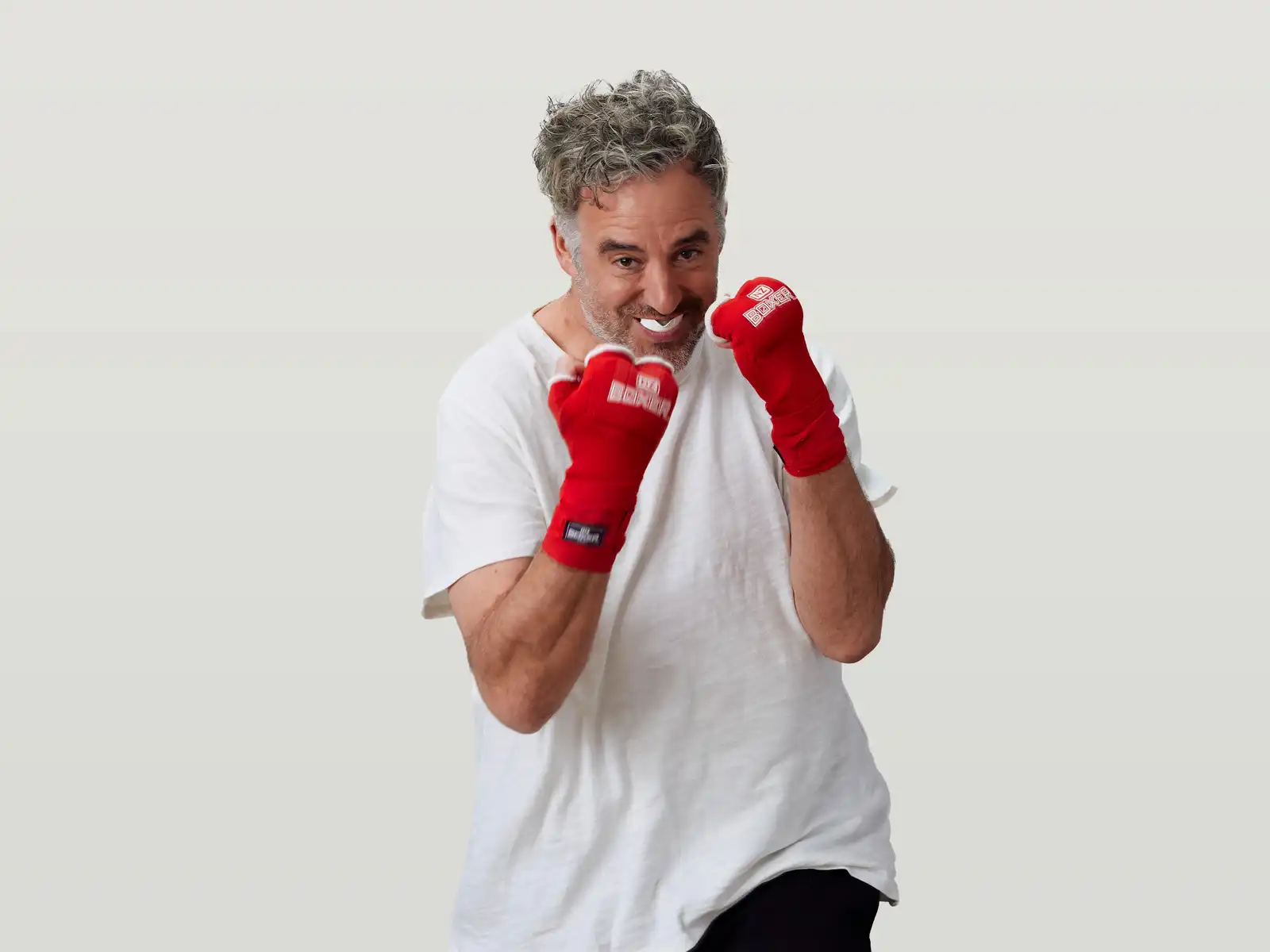 Mike boxing in a white shirt and red boxing gloves
